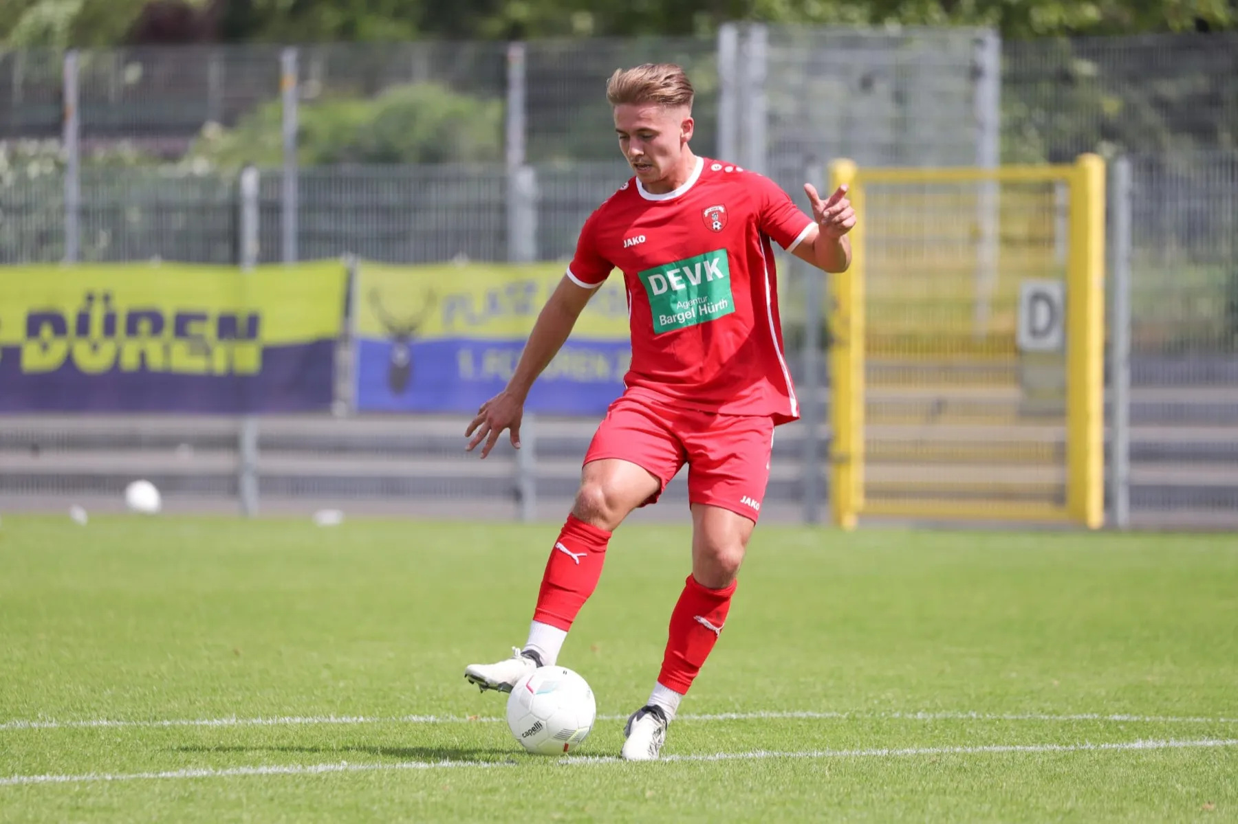 Marcus Peters als Spieler im roten Trikot des 1. FC Düren am Ball